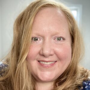 A woman with long blonde hair smiling for the camera.